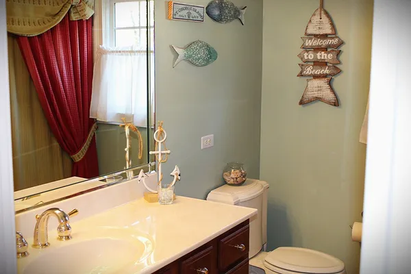 a bathroom with a sink vanity mirror and toilet