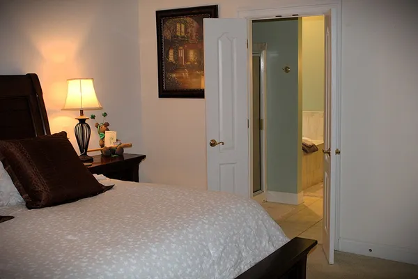 a bedroom with a bed and wooden floor