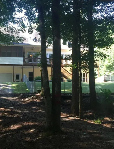 a view of a house with backyard garden and patio