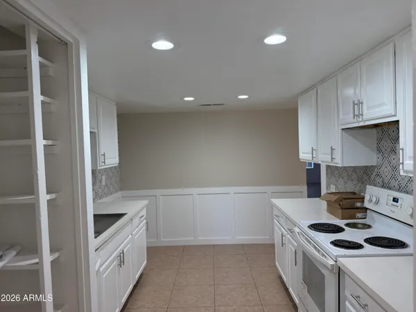 a kitchen with white cabinets and a stove top oven
