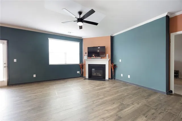 an empty room with fireplace chandelier and windows