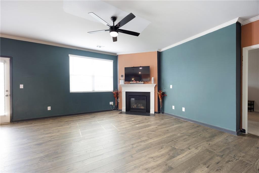 7571 Deerridge Way Fairburn, GA 30213 - Photo 11 of 26 an empty room with fireplace chandelier and windows