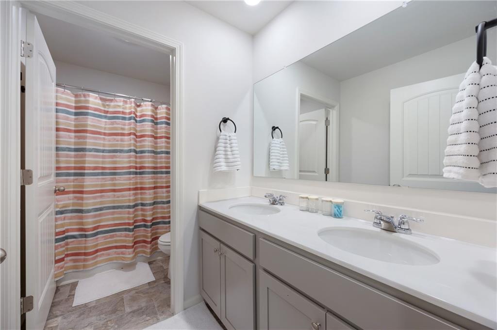 7571 Deerridge Way Fairburn, GA 30213 - Photo 23 of 26 a bathroom with a sink and a mirror