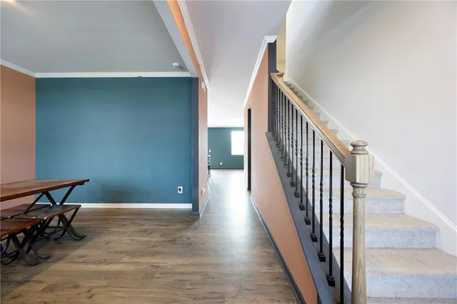 a view of a hallway with wooden floor and stairs