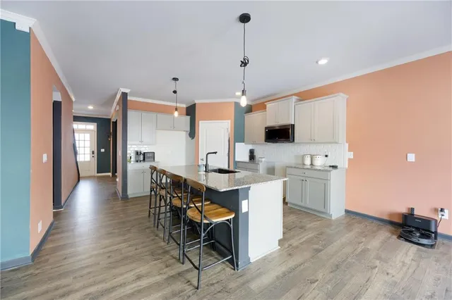 a view of kitchen with stainless steel appliances kitchen island granite countertop a stove a sink a dining table and chairs with wooden floor
