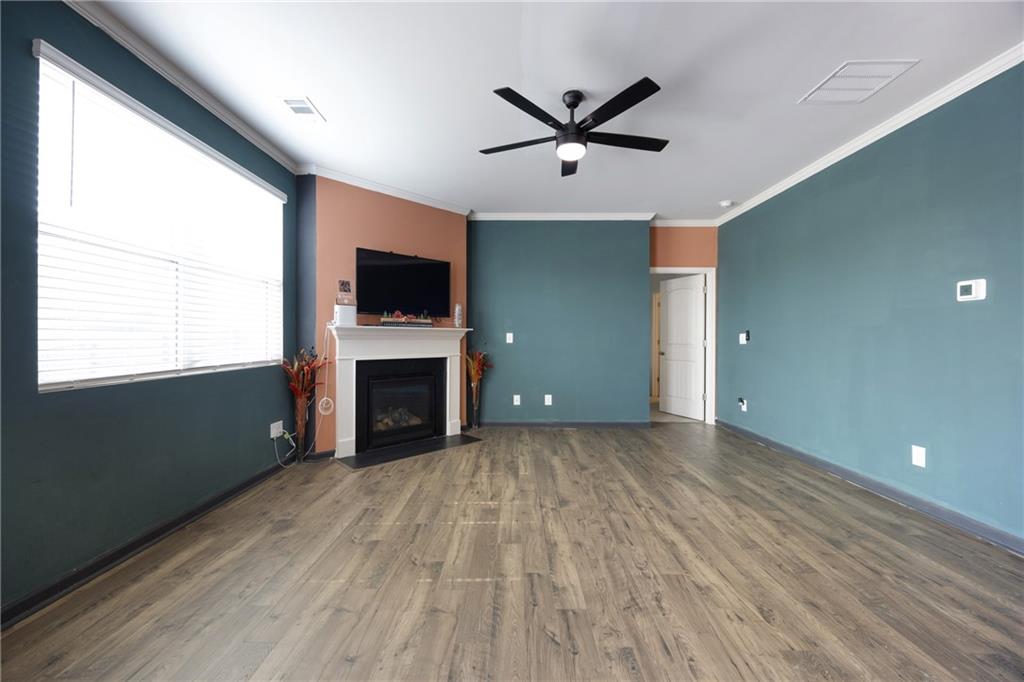 7571 Deerridge Way Fairburn, GA 30213 - Photo 10 of 26 a view of a livingroom with a fireplace a ceiling fan and windows