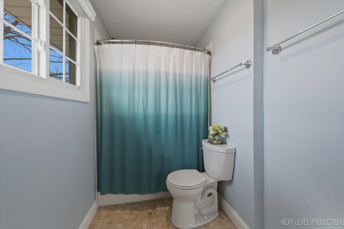 1601 Castbourne Court Wheaton, IL 60189 - Photo 15 of 30 a bathroom with a toilet and a shower curtain
