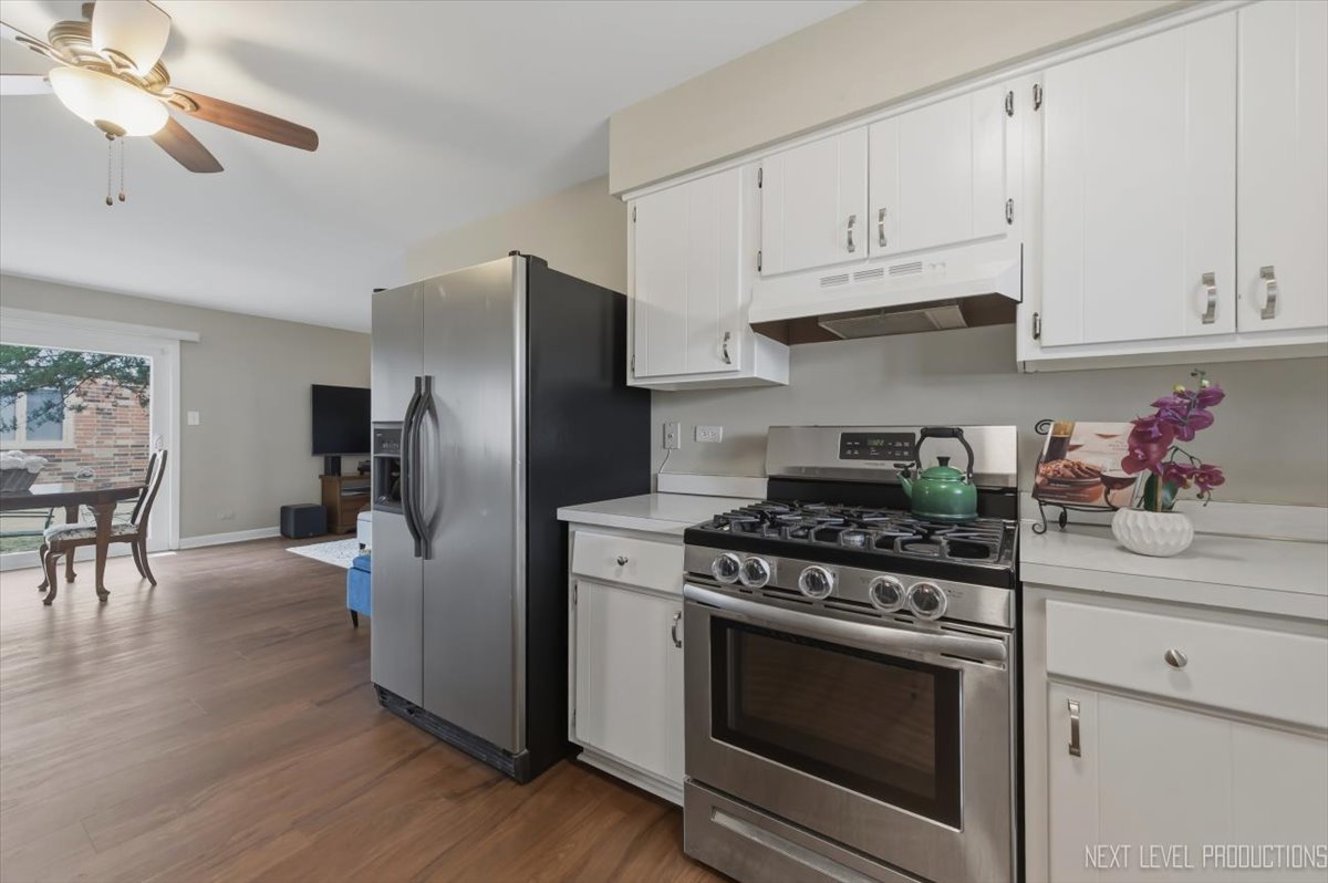 1601 Castbourne Court Wheaton, IL 60189 - Photo 4 of 30 a kitchen with stainless steel appliances white cabinets a stove a refrigerator and island