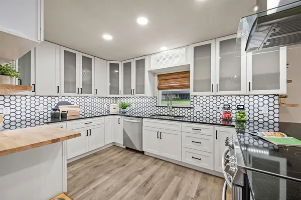 a kitchen with granite countertop white cabinets and white appliances