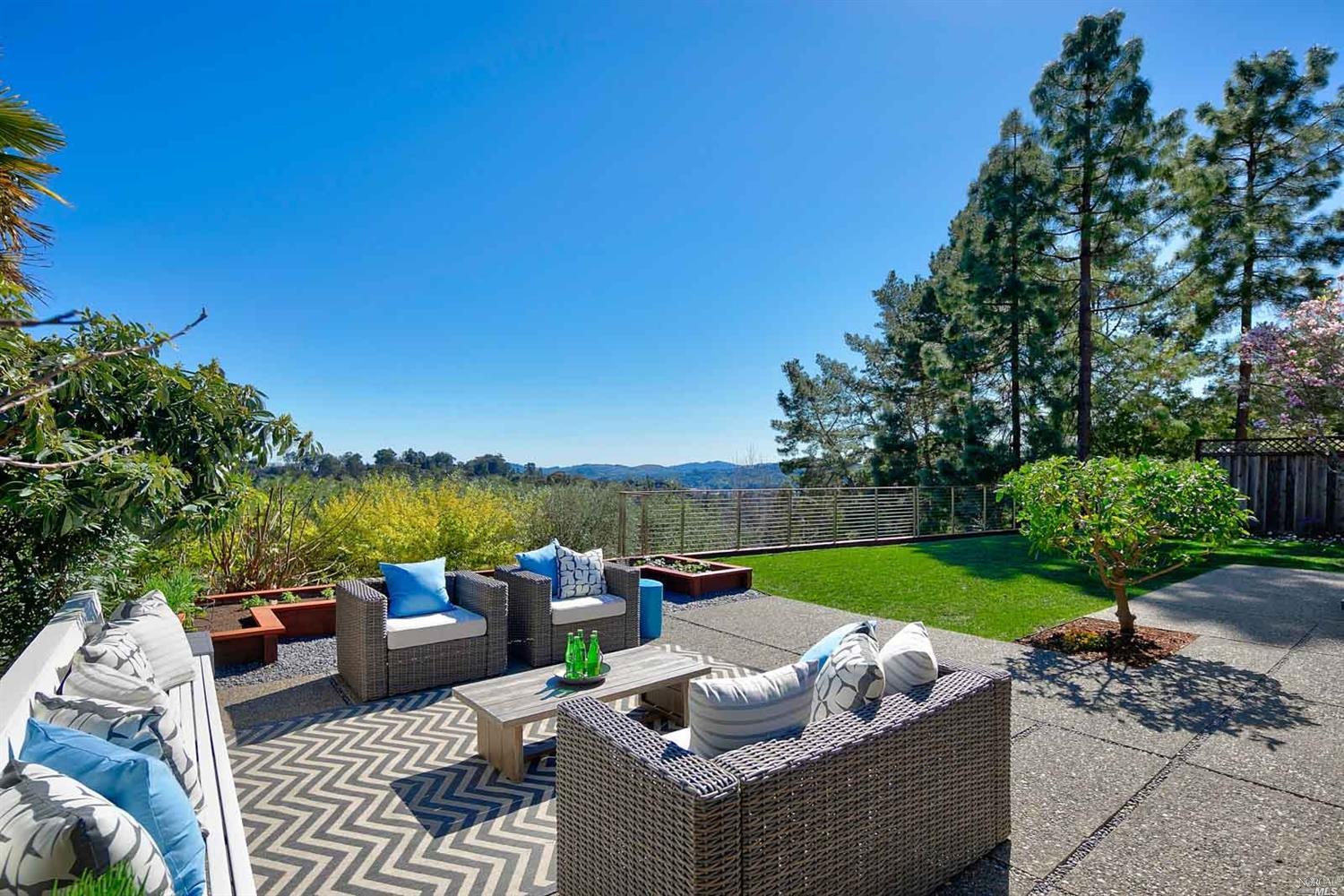 a view of a patio with couches and a table and chairs with garden view