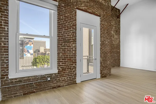 a view of empty room with wooden floor and white walls