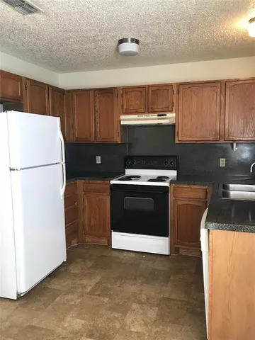 a kitchen with a stove a refrigerator and a sink