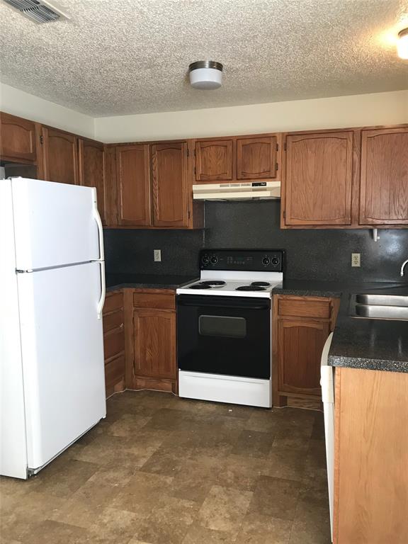 a kitchen with a stove a refrigerator and a sink