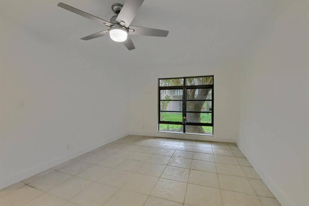 516 Osprey Drive, Unit 14A Delray Beach, FL 33444 - Photo 15 of 20 an empty room with fan and windows