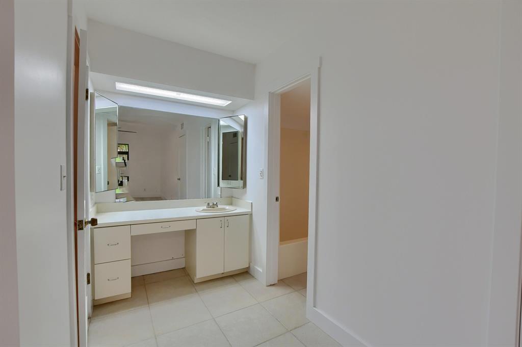 516 Osprey Drive, Unit 14A Delray Beach, FL 33444 - Photo 16 of 20 a bathroom with a sink a mirror and a bathtub