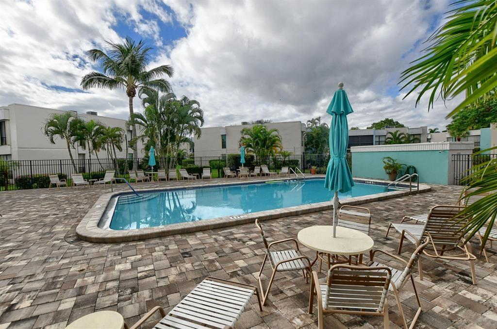 516 Osprey Drive, Unit 14A Delray Beach, FL 33444 - Photo 20 of 20 a view of swimming pool with a table and chairs