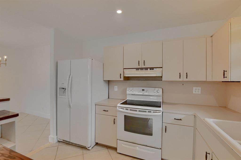516 Osprey Drive, Unit 14A Delray Beach, FL 33444 - Photo 6 of 20 a kitchen with cabinets and white appliances