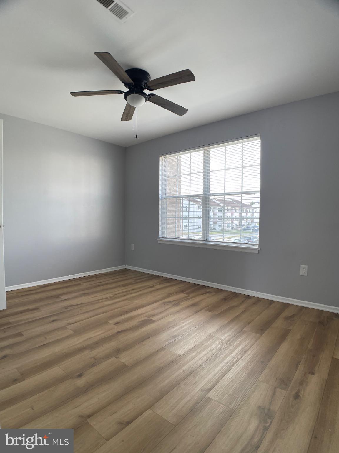 1401 Key Parkway, Unit 204 Frederick, MD 21702 - Photo 11 of 25 an empty room with wooden floor and windows