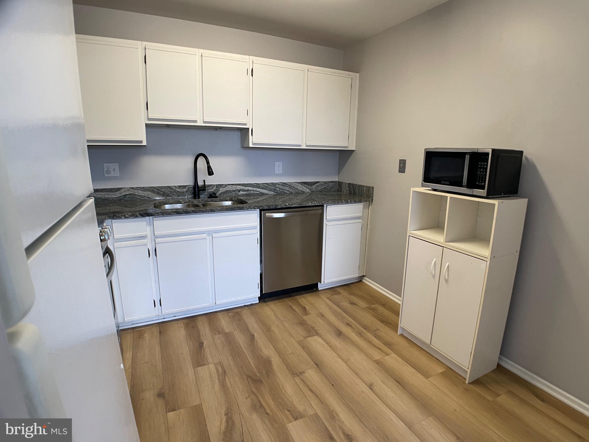 1401 Key Parkway, Unit 204 Frederick, MD 21702 - Photo 19 of 25 a kitchen with granite countertop white cabinets and stainless steel appliances