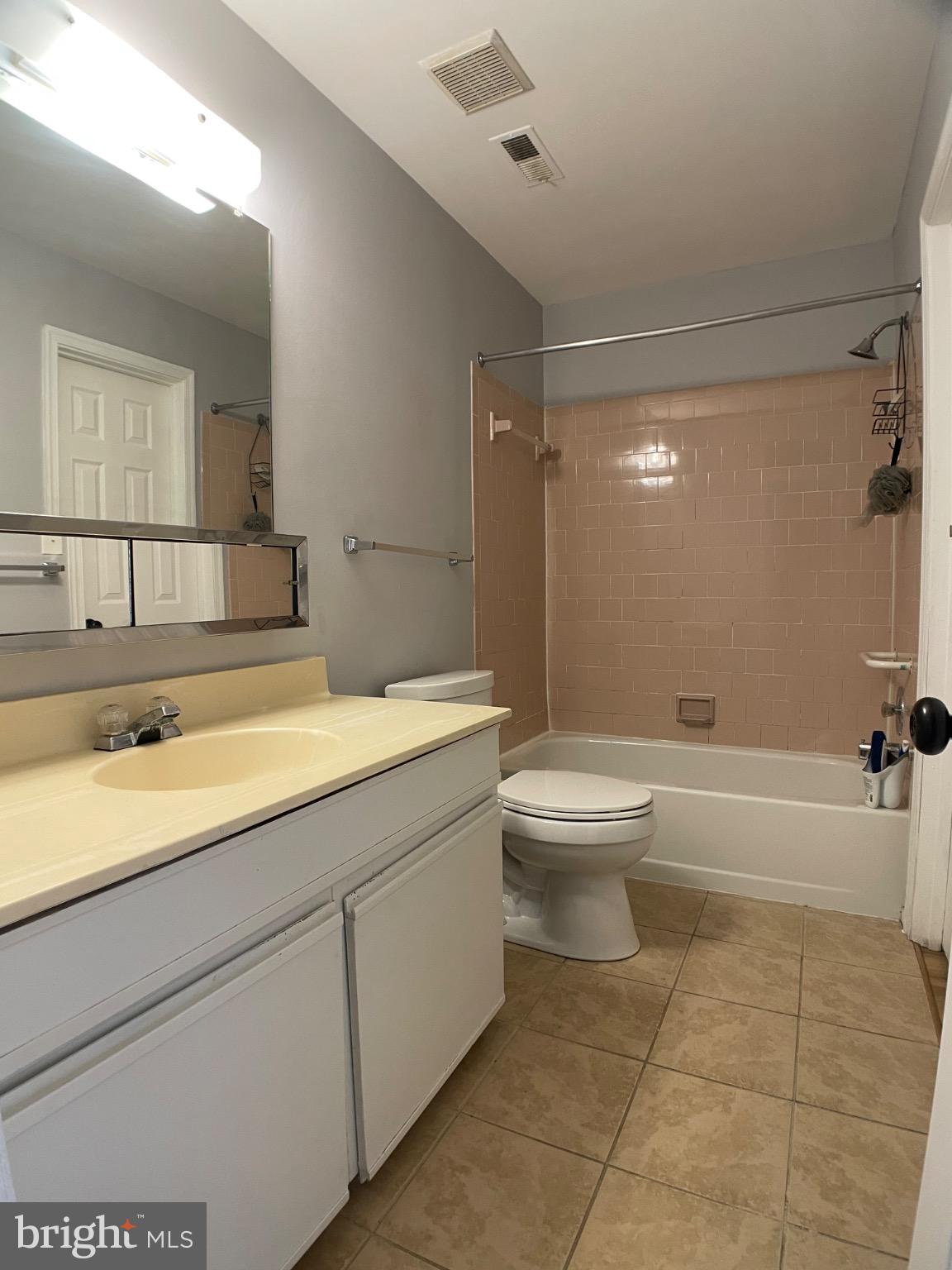 1401 Key Parkway, Unit 204 Frederick, MD 21702 - Photo 21 of 25 a bathroom with a granite countertop sink a toilet and bathtub