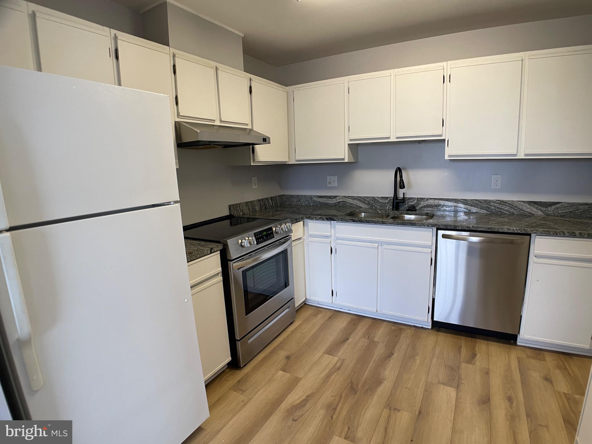 1401 Key Parkway, Unit 204 Frederick, MD 21702 - Photo 3 of 25 a kitchen with granite countertop white cabinets and white appliances