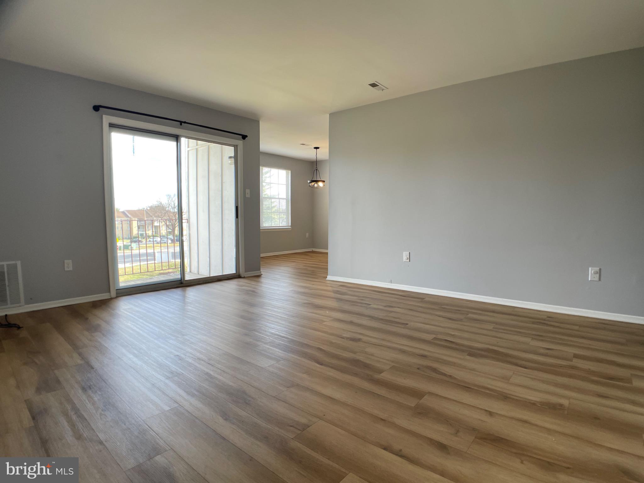 1401 Key Parkway, Unit 204 Frederick, MD 21702 - Photo 5 of 25 a view of an empty room with wooden floor and a window