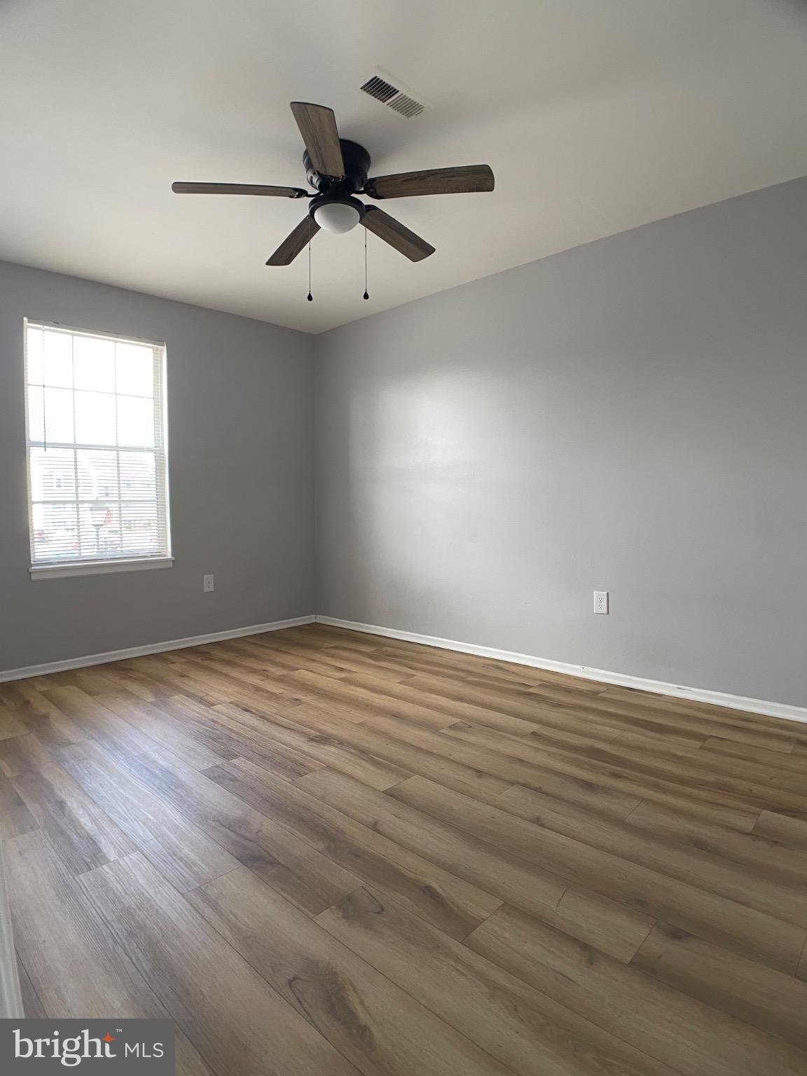 1401 Key Parkway, Unit 204 Frederick, MD 21702 - Photo 10 of 25 an empty room with wooden floor fan and windows