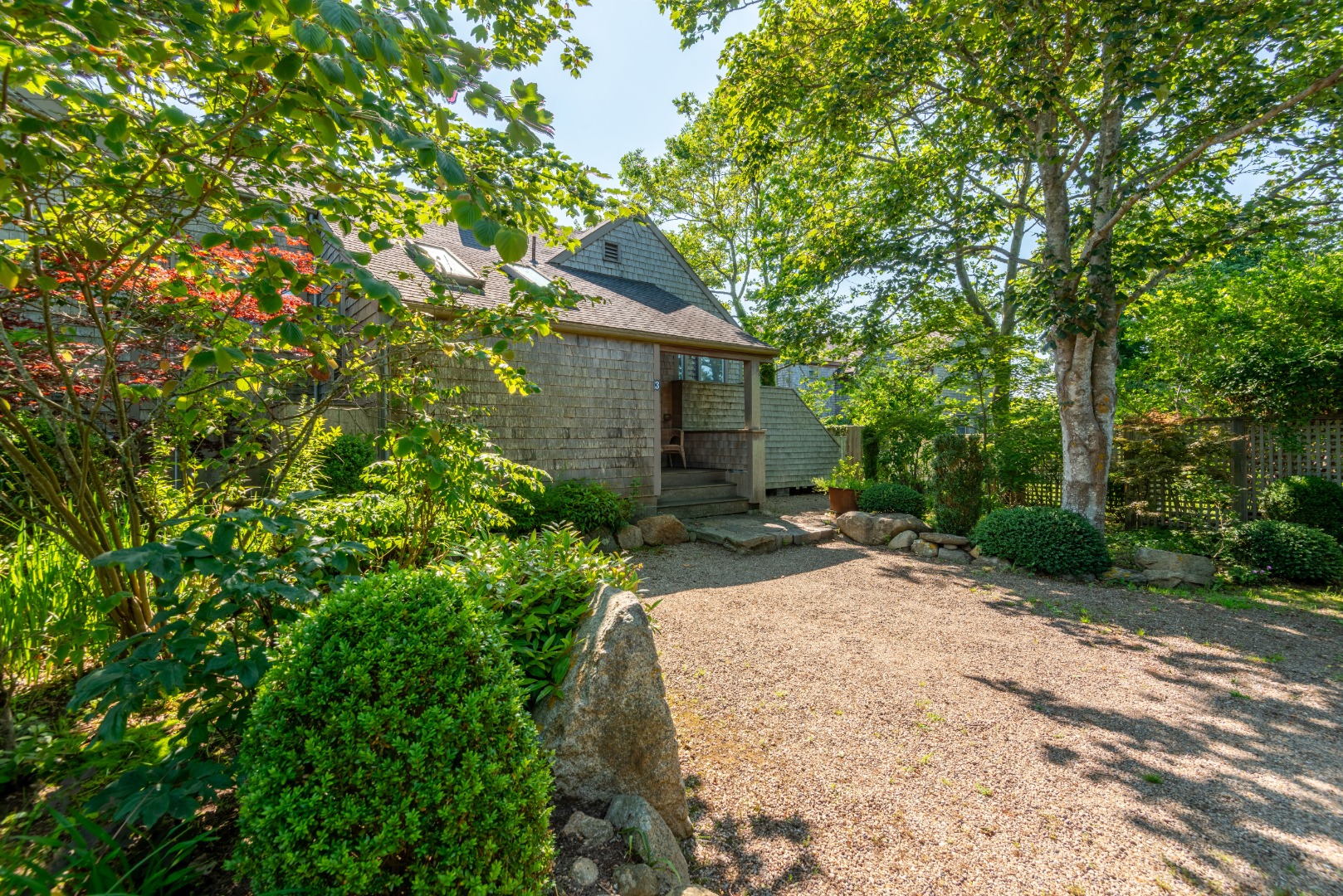 3 Bear Street Nantucket, MA 02554 - Photo 37 of 38 a view of a backyard with potted plants and large trees