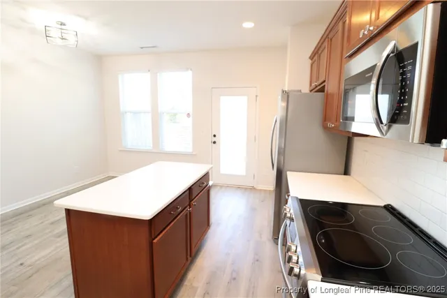 a kitchen with a refrigerator and a stove top oven