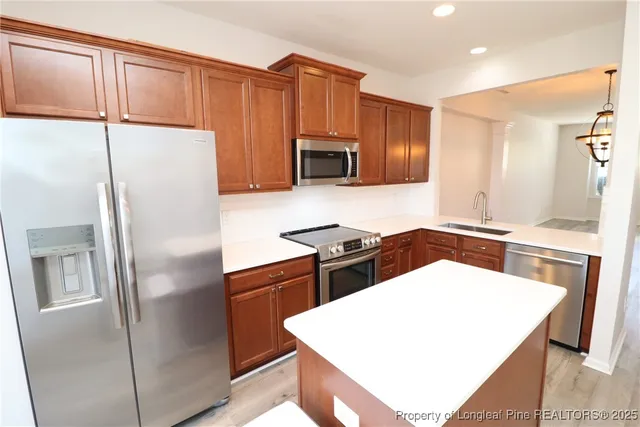 a kitchen with stainless steel appliances a refrigerator sink and microwave
