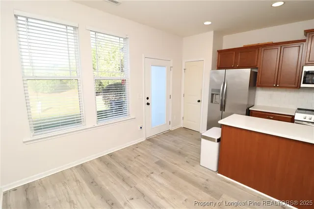a kitchen with stainless steel appliances a refrigerator sink and microwave