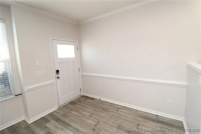 an empty room with wooden floor and white walls
