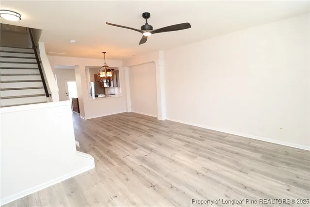 a view of a livingroom with wooden floor and a ceiling fan