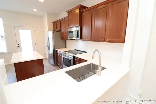 a kitchen with stainless steel appliances a sink a stove and refrigerator