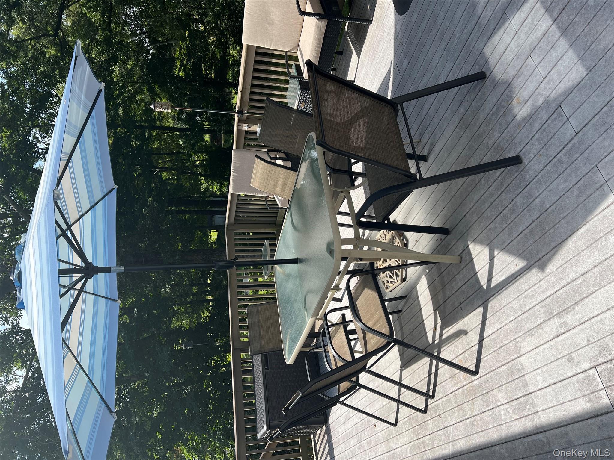 24 Montfort Road Wappingers Falls, NY 12590 - Photo 34 of 45 a patio with wooden floor a yard a table and chairs