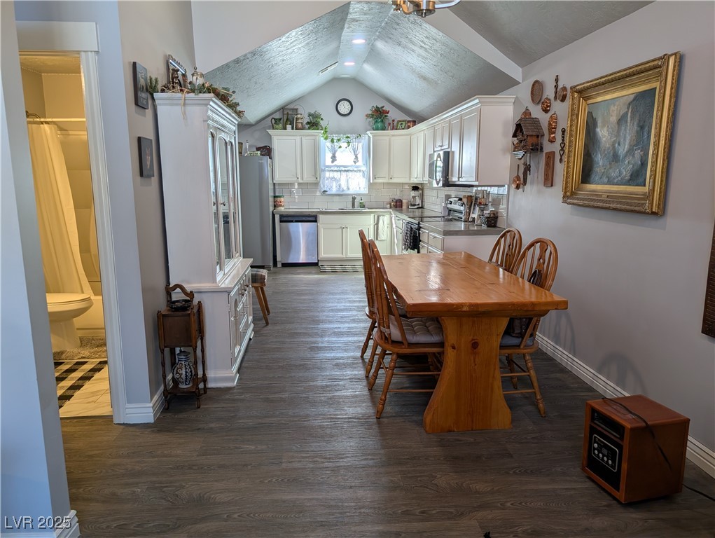 327 High Street Pioche, NV 89043 - Photo 11 of 27 Dining space featuring vaulted ceiling and dark wood-style floors