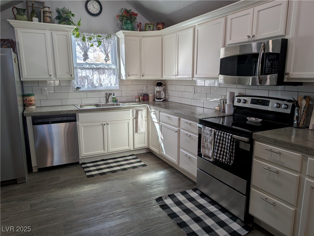 327 High Street Pioche, NV 89043 - Photo 10 of 27 Kitchen with white cabinetry, decorative backsplash, dark wood-style floors, and lofted ceiling