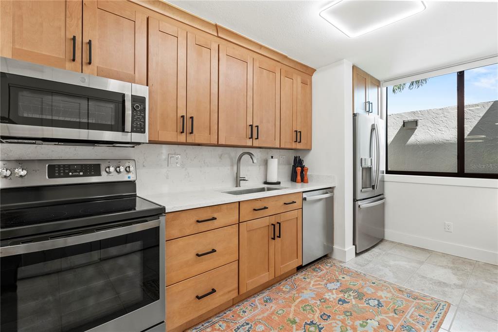 806 Bayport Way, Unit 806 Longboat Key, FL 34228 - Photo 12 of 79 a kitchen with stainless steel appliances white cabinets and a stove top oven