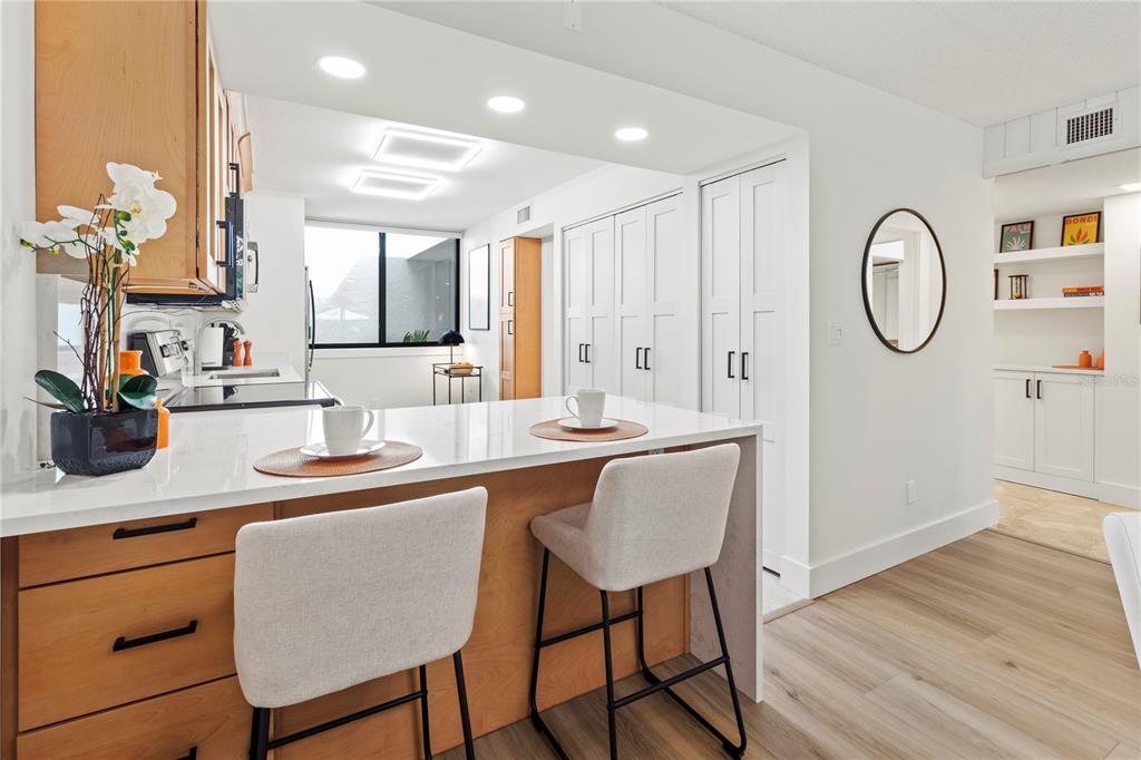 806 Bayport Way, Unit 806 Longboat Key, FL 34228 - Photo 15 of 79 a dining hall with stainless steel appliances granite countertop a dining table chairs and wooden floor