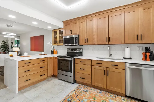 a kitchen with stainless steel appliances white cabinets and a stove top oven