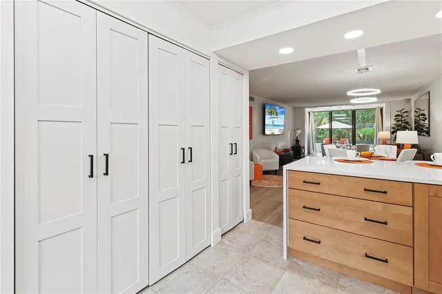 a dining hall with stainless steel appliances granite countertop a dining table chairs and wooden floor