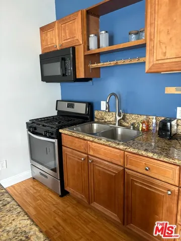 a kitchen with stainless steel appliances granite countertop a sink and a microwave