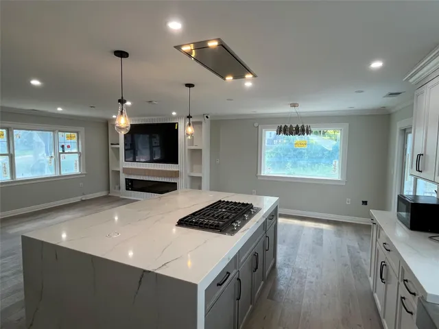 a kitchen with stainless steel appliances granite countertop a stove top oven a sink dishwasher and a refrigerator