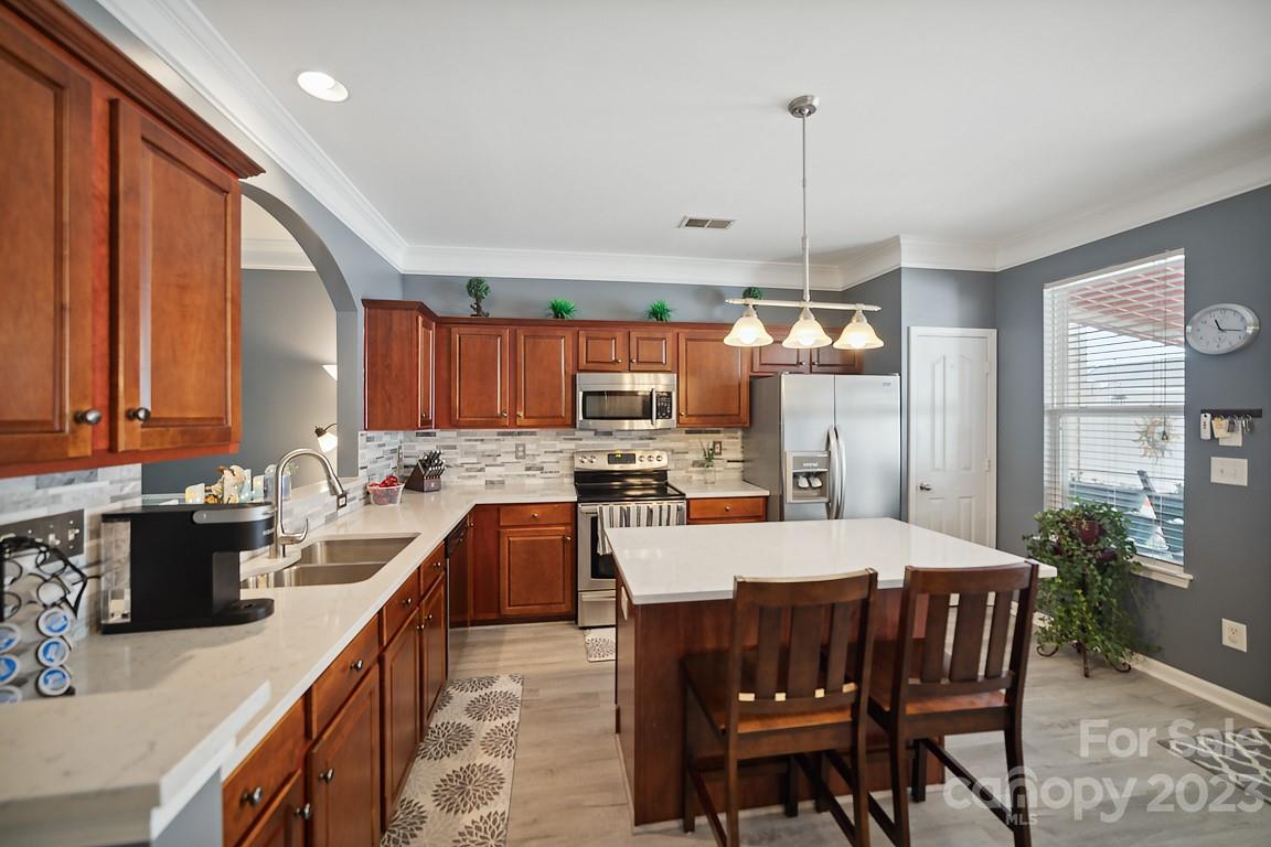 9526 Inglenook Lane Huntersville, NC 28078 - Photo 7 of 20 a kitchen with a dining table chairs sink and stove