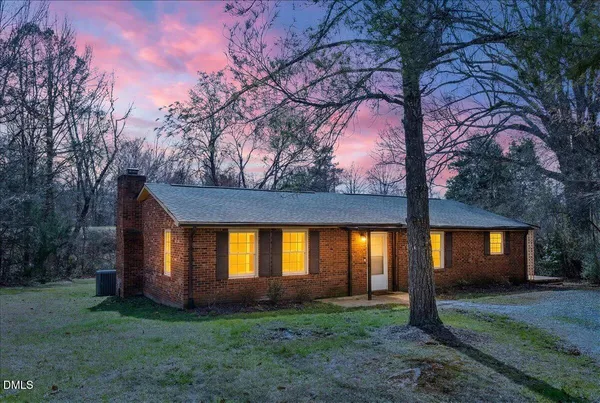 a view of a house with backyard and tree