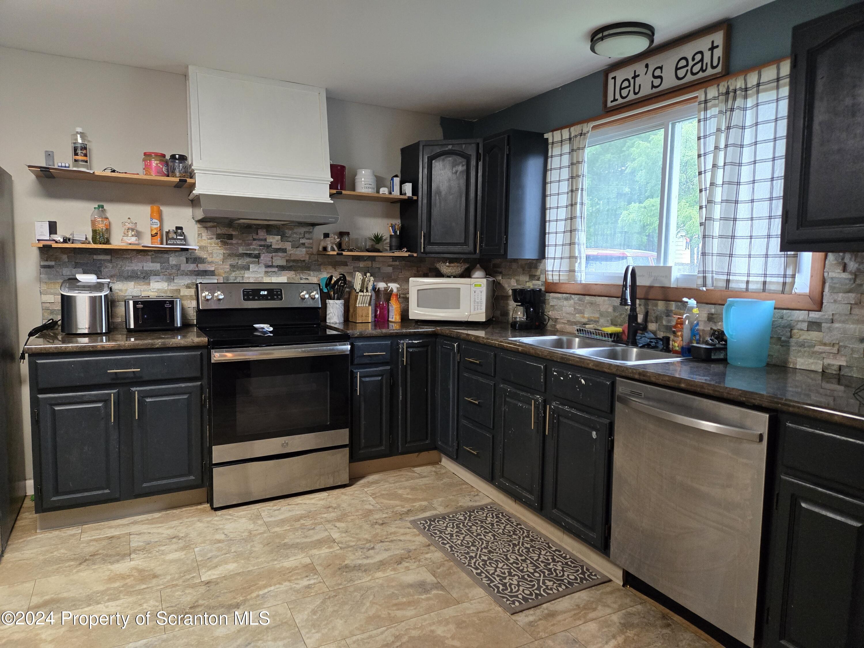 1609 State Rte 3005 Meshoppen, PA 18630 - Photo 3 of 18 a kitchen with stainless steel appliances granite countertop a stove a sink and a microwave