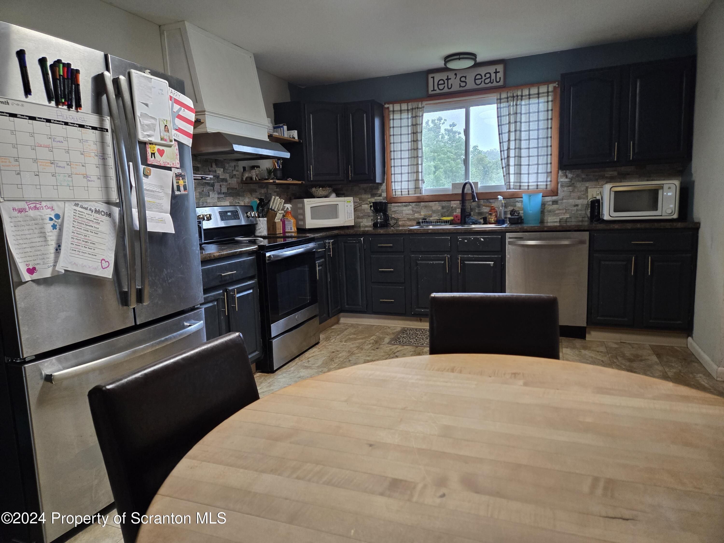 1609 State Rte 3005 Meshoppen, PA 18630 - Photo 4 of 18 a kitchen with stainless steel appliances kitchen island granite countertop a refrigerator stove top oven and sink