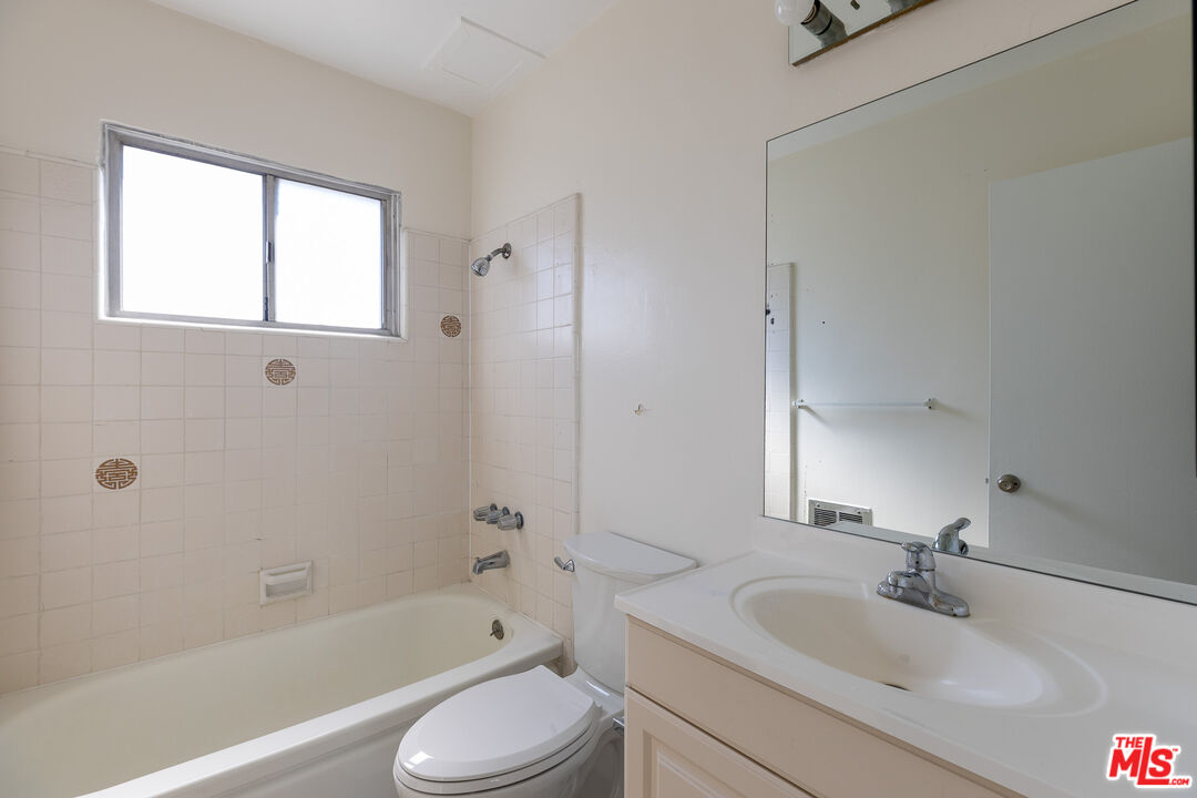 1295 Federal Avenue, Unit 8 Los Angeles, CA 90025 - Photo 12 of 12 a bathroom with a bathtub shower sink vanity mirror and toilet