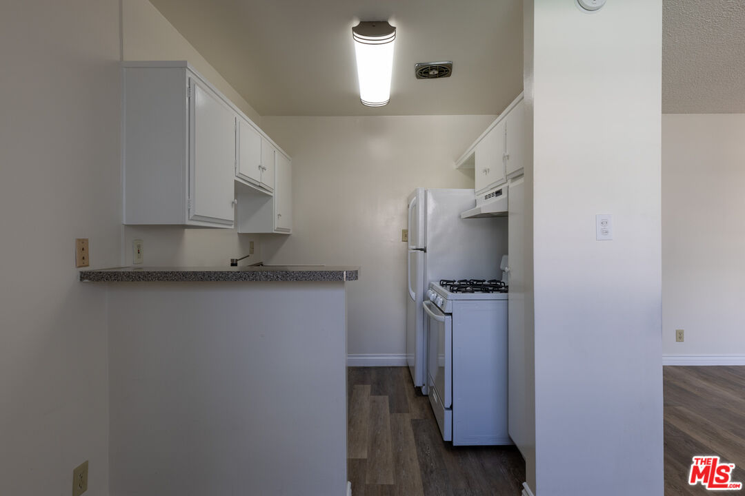 1295 Federal Avenue, Unit 8 Los Angeles, CA 90025 - Photo 6 of 12 a kitchen with a refrigerator and cabinets