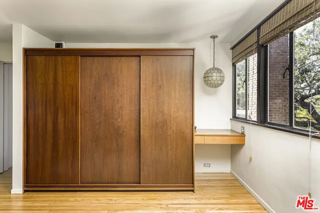 a view of a room that has a large window and wooden door